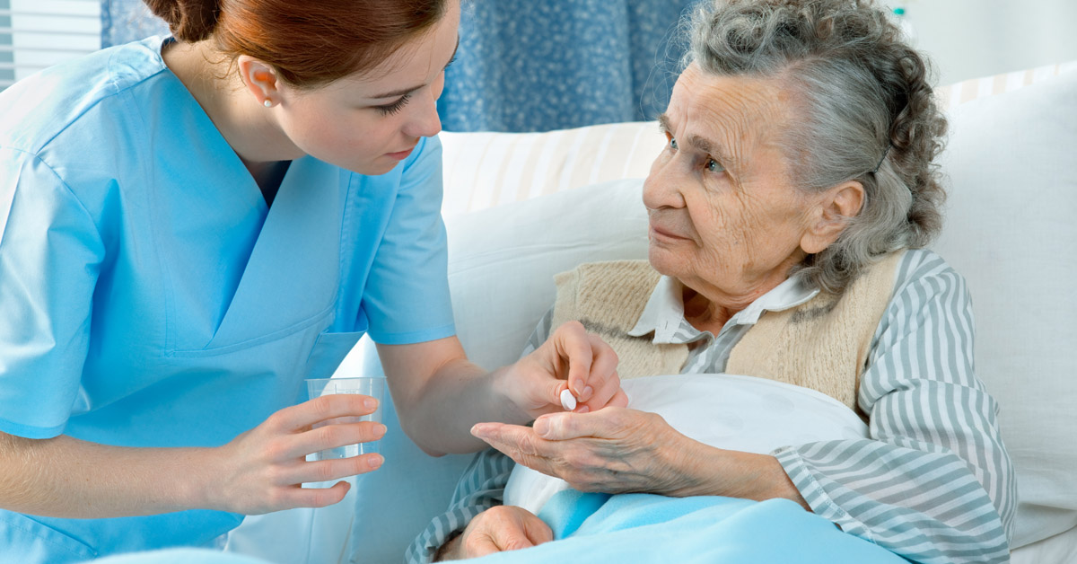 Nurse giving her patient her medication.